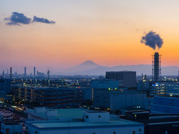 Illuminated cityscape against sky during sunset