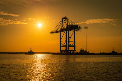 Silhouette sailboat on sea against sky during sunset