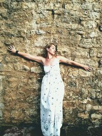 Portrait of woman standing against wall