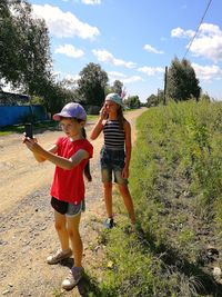 Full length of mother and daughter against sky