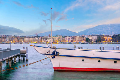 Sailboats moored in sea against blue sky