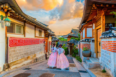 Rear view of woman outside temple against building