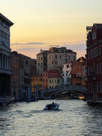 View of buildings at waterfront against cloudy sky