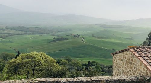 Scenic view of agricultural landscape and houses against mountains