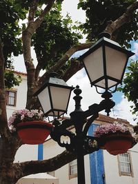 Low angle view of illuminated lamp hanging against clear sky