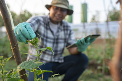 Midsection of man holding plant