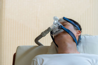 Male patient with medical oxygen equipment sleeping at hospital