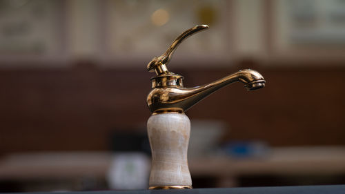 Close-up of faucet on table at home