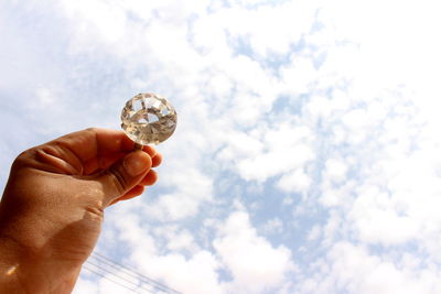 Low angle view of cropped hand against clear sky