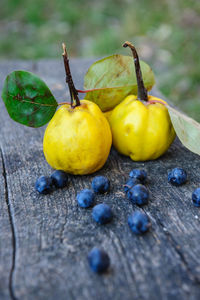 Close-up of quinces with blueberries on wooden table