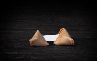 Close-up of bread on table against black background