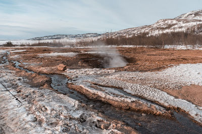 Scenic view of hot spring against sky