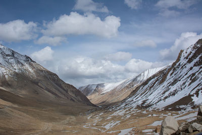 Scenic view of snowcapped mountains against cloudy sky