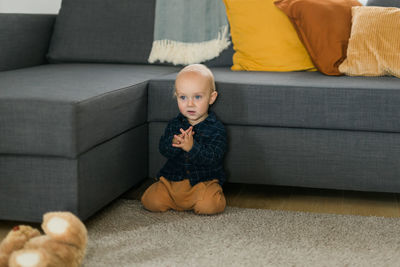 Portrait of boy sitting on sofa at home