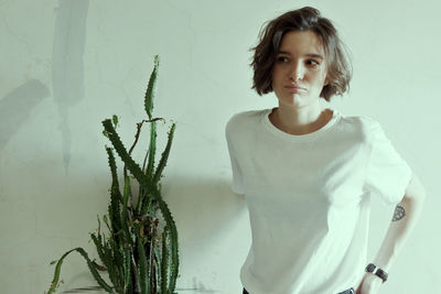 Portrait of woman standing against wall
