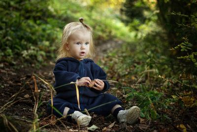 Portrait of girl sitting on land