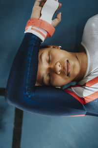 Directly above shot of female athlete with eyes closed resting on floor