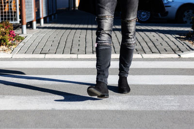 Low section of man walking on road