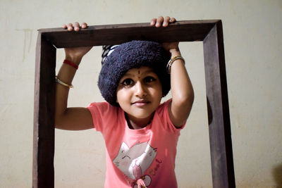 Portrait of a smiling young woman standing at home