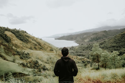 Rear view of man standing on mountain