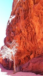 View of frozen rock formation against sky during winter