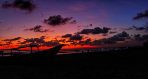 Scenic view of beach against romantic sky at sunset