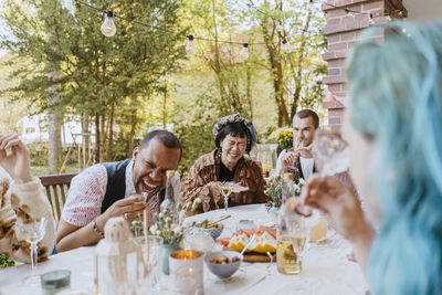 Friends of lgbtq community enjoying drinks during dinner party in back yard