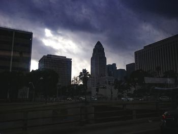 Buildings in city against cloudy sky