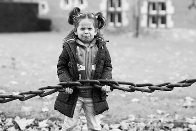 Portrait of cute girl holding chain outdoors