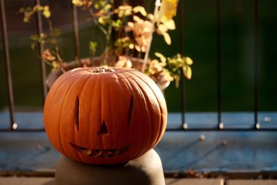 Close-up view of pumpkin against bollard during halloween