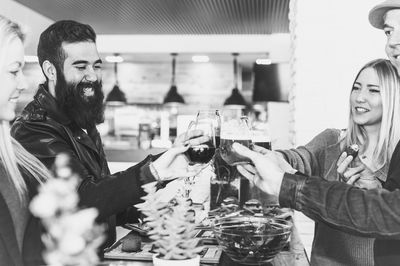 Friends toasting wineglass at table in bar