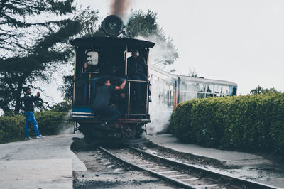Train by railroad tracks against clear sky