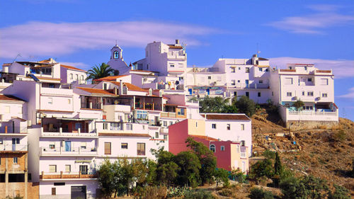 Buildings in town against blue sky