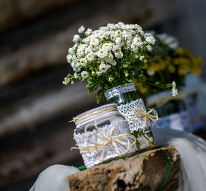 Close-up of flowers in mason jar on wood