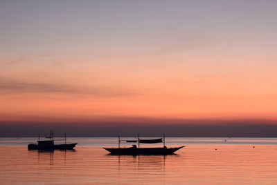 Boat moored in sea against sky during sunset