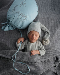 Cute newborn baby sleeping on gray blanket and holding craft wooden star. bed vibes.