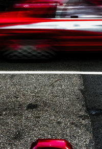 Low section of red car on street