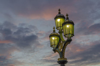 Low angle view of illuminated street light against sky