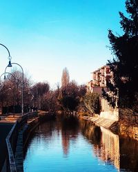 Swimming pool by river against clear blue sky