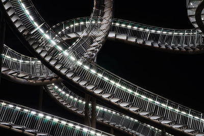 Low angle view of illuminated bridge against sky at night