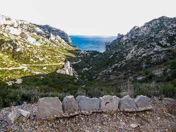 Scenic view of sea by cliff against clear sky