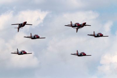 Low angle view of fighter planes flying against sky