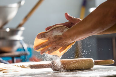 Cropped hands of person making chapatti in kitchen at home