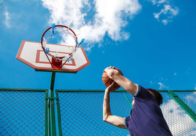 Low angle view of basketball hoop against blue sky