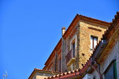 Low angle view of old building against clear blue sky