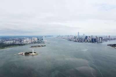 Cityscape by sea against sky