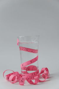 Close-up of pink glass over white background