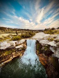 Scenic view of waterfall against sky