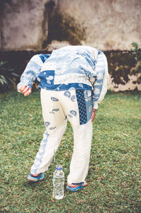 Rear view of boy standing on field