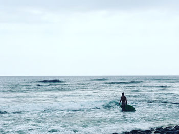 Man in sea against sky